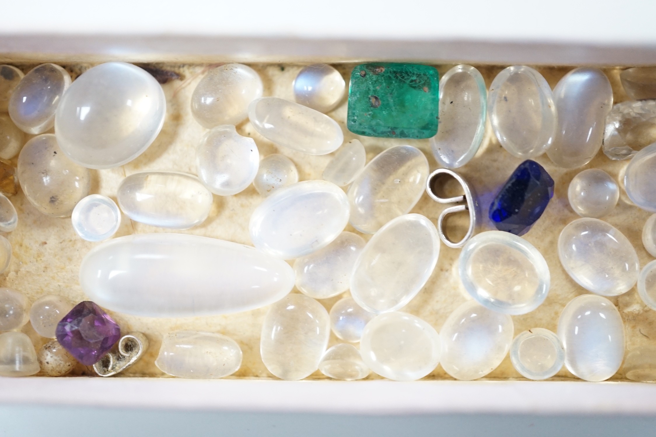 A small quantity of unmounted cabochon moonstones of varying sizes and four other unmounted coloured stones including green paste.